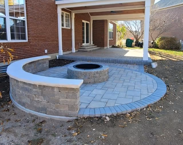 Custom stone fire pit and seating area built by Lawn Impressions
